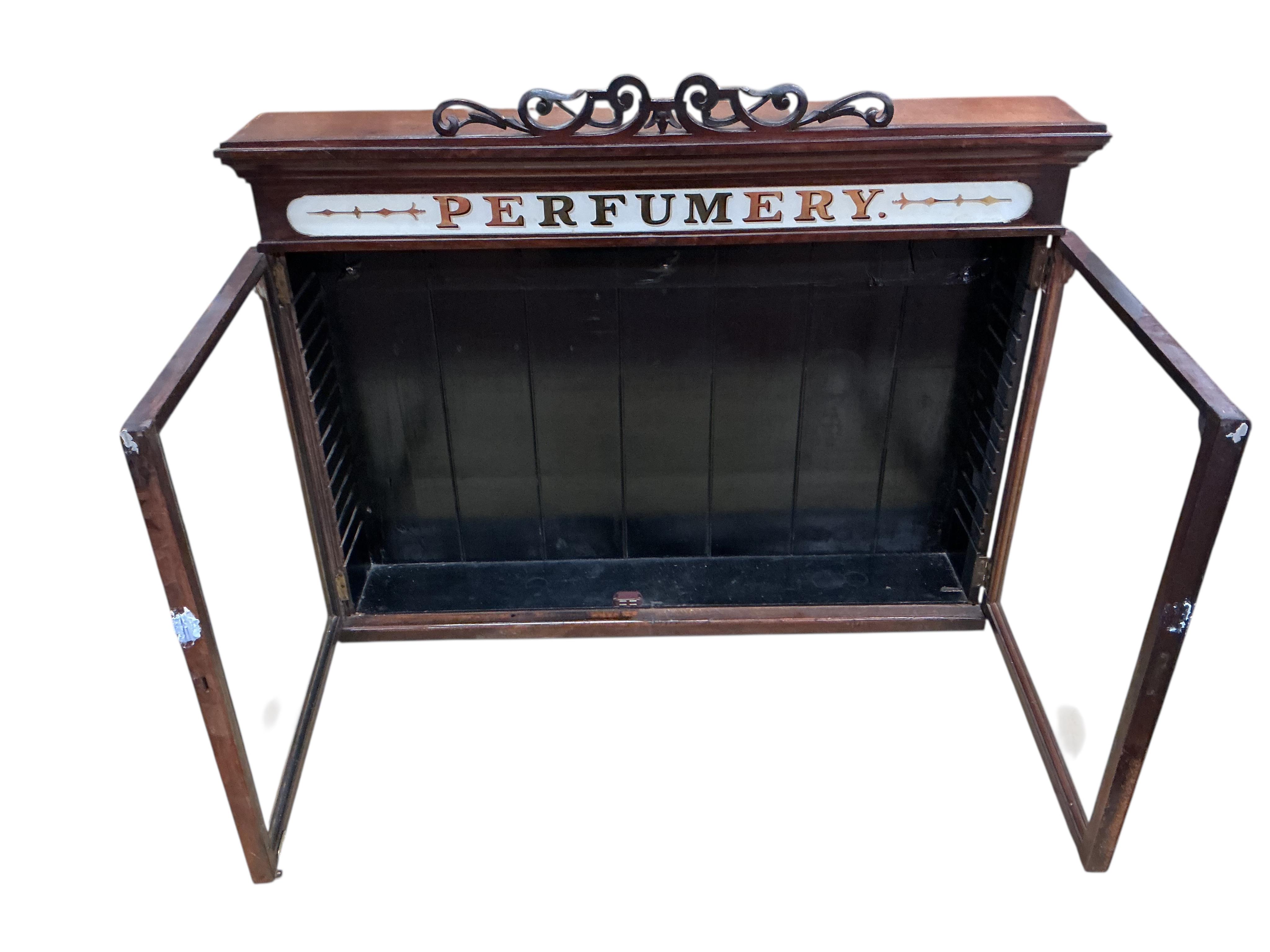 A late Victorian mahogany perfumery cabinet with printed glass frieze, width 95cm, depth 18cm, height 76cm